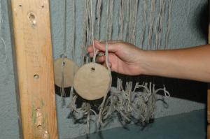 Attaching the warp threads to the loom-weights. Photo S. Spantidaki.